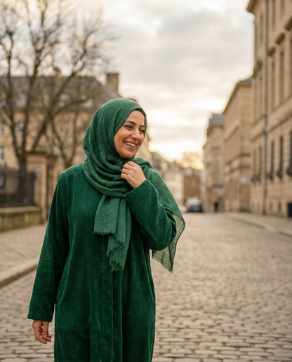Woman wearing emerald green corduroy winter abaya outdoors in soft winter light